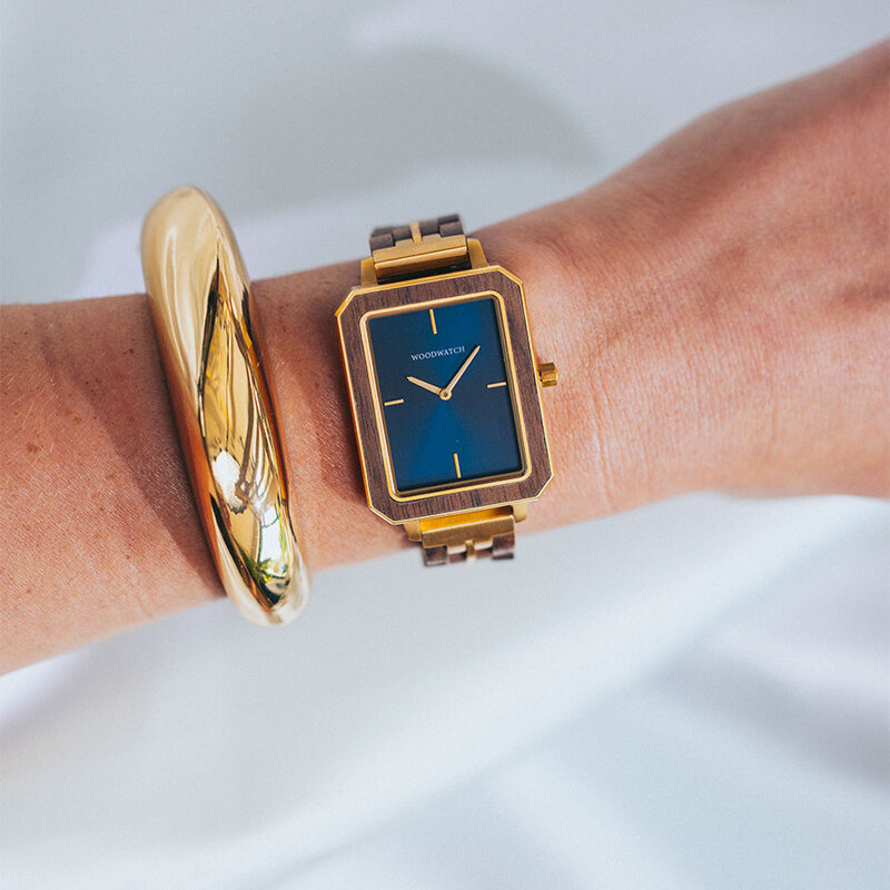 The Elegance Midnight Shade is crafted from walnut wood and stainless steel, featuring a navy blue dial with brushed gold metal details.