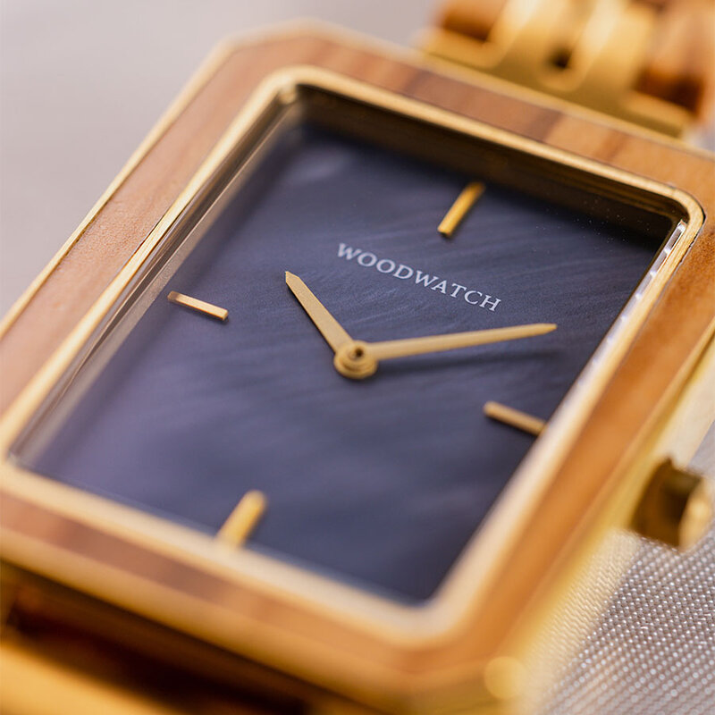 The Elegance Blue Pearl is crafted from olive wood and stainless steel, featuring a blue mother-of-pearl dial with brushed gold metal details.