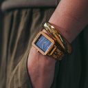 The Elegance Blue Pearl is crafted from olive wood and stainless steel, featuring a blue mother-of-pearl dial with brushed gold metal details.