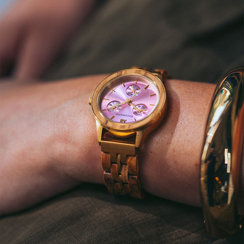The Radiance Rose Champagne is crafted from olive wood and stainless steel brushed gold, featuring a light pink dial and brushed gold metal details.