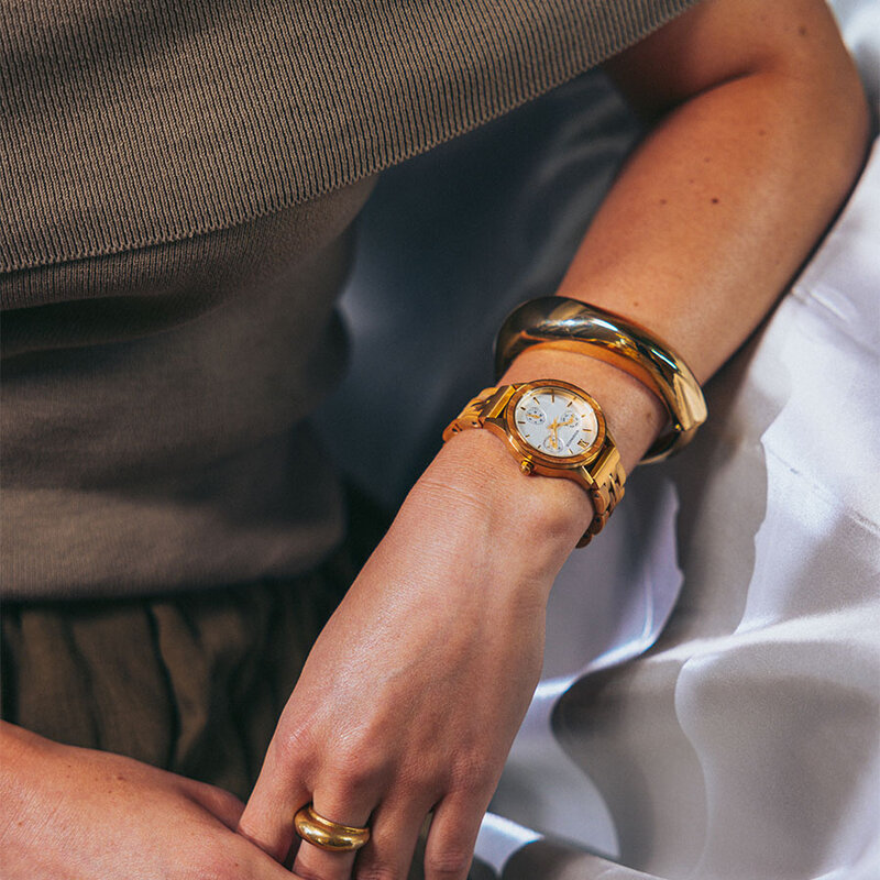 The Radiance Ivory Pearlworld is crafted from olive wood and stainless steel brushed gold, featuring a pearl white dial and brushed gold metal details.