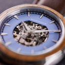 The Nostalgia Espresso is crafted from walnut wood and stainless steel, featuring a matte blue dial, dark brown vegan leather strap, and brushed silver metal details.