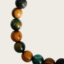 Made with rosewood beads, volcanic beads, dark green natural stone beads, and a matte black brass closure. Adjustable, with 8mm beads to fit most wrist sizes.