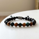 Made with rosewood beads, volcanic beads, dark green natural stone beads, and a matte black brass closure. Adjustable, with 8mm beads to fit most wrist sizes.