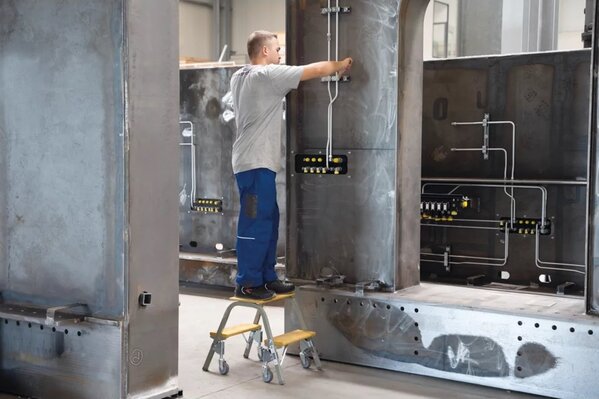 Roossien Stalen opstap met 2 houten treden, zwenkwielen en drukveer rem