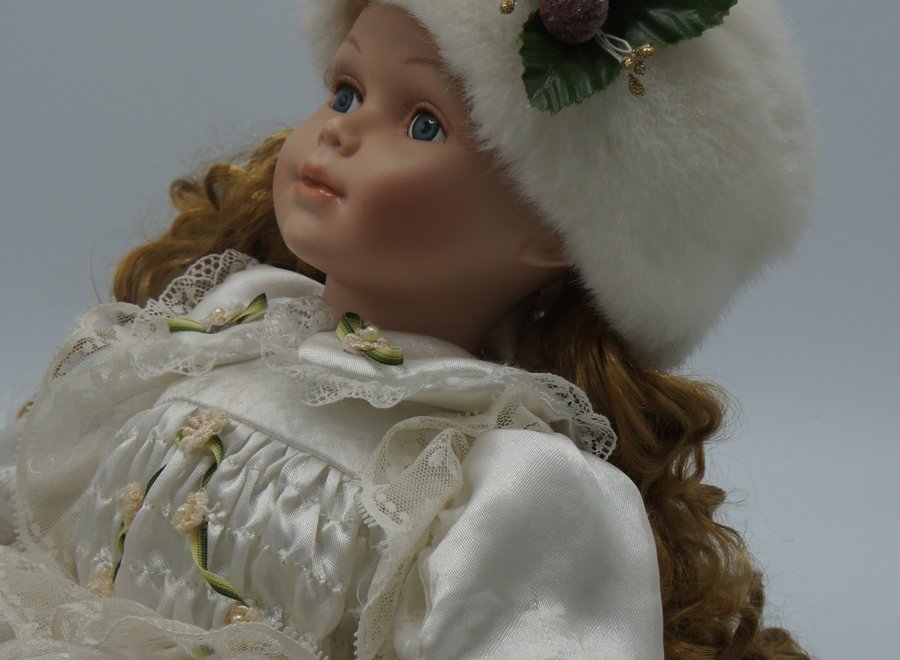 Decorative, sitting doll in a winter atmosphere.