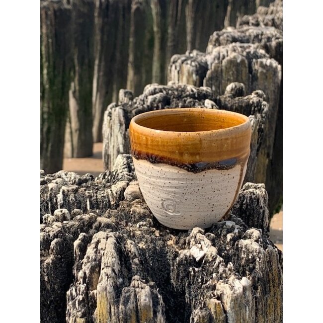 artisann With the turntable handmade cup of speckled Pyriet clay with a beautiful Floating orange brown white high-firing glaze.