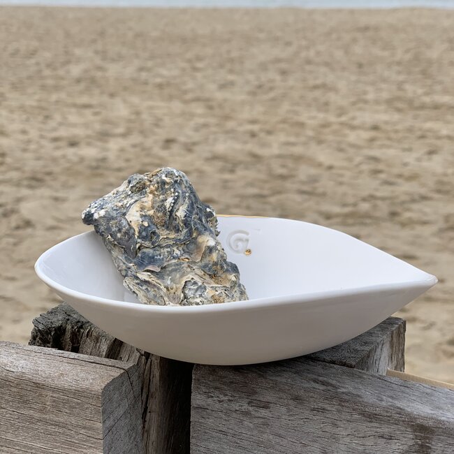 Handgemaakt schaaltje of kommetje in witte porselein met een blinkende transparante glazuur afgewerkt met een schelpje en een gouden speelse touch