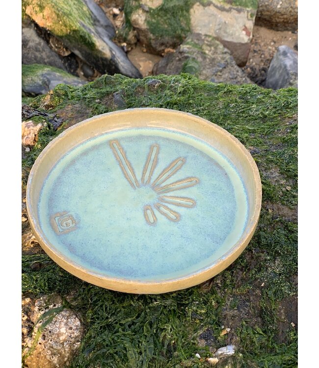 Cette assiette en céramique contemporaine faite main avec bord surélevé a un fond de présentation rugueux avec une structure à rayures avec le soleil comme inspiration.