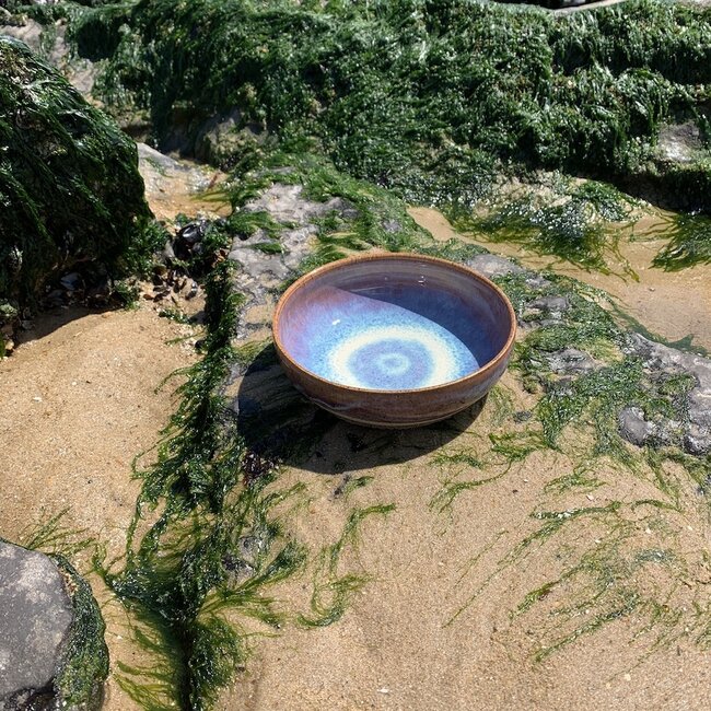 With the turntable handmade bowl of Pyerite clay with a beautiful Floating magenta roos high-firing glaze.