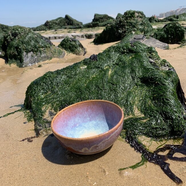 With the turntable handmade bowl of Pyerite clay with a beautiful Floating magenta roos high-firing glaze.
