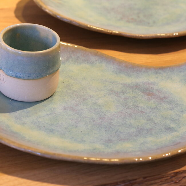 Unique handmade ceramic plate with round hollow in boomerang shape