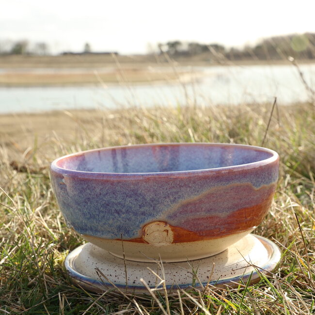 With the turntable handmade bowl of Pyerite clay with a beautiful Floating magenta roos high-firing glaze.