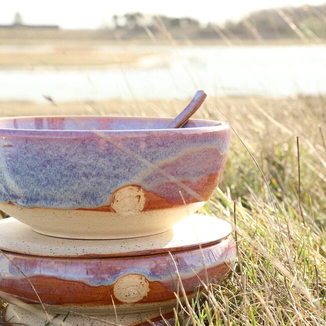With the turntable handmade bowl of Pyerite clay with a beautiful Floating magenta roos high-firing glaze.