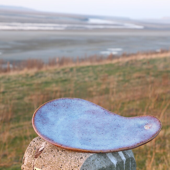Assiette unique en céramique faite à la main avec un creux rond en forme de boomerang