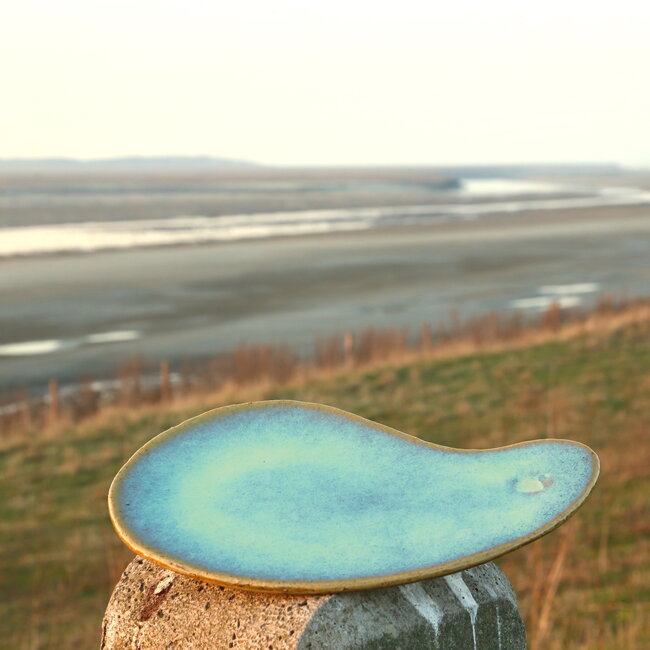 Unique handmade ceramic plate with round hollow in boomerang shape