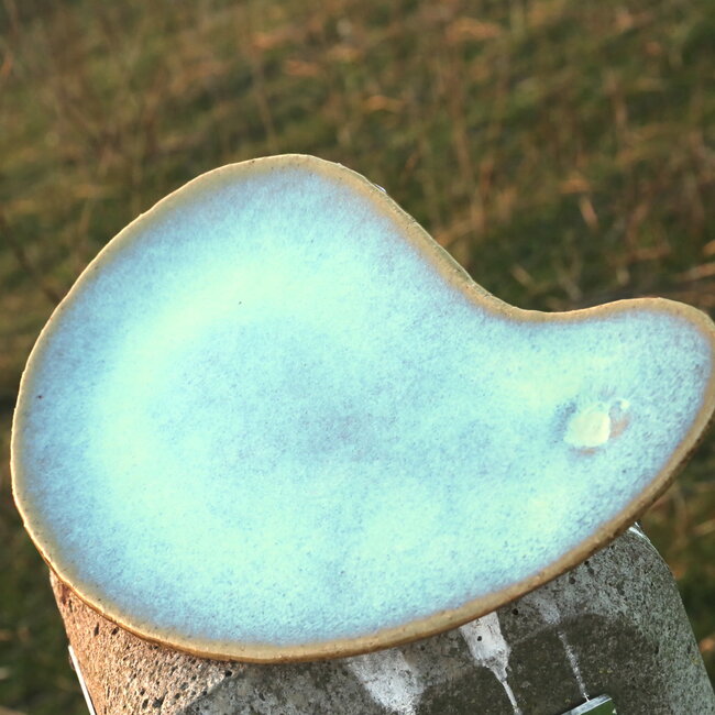 Unique handmade ceramic plate with round hollow in boomerang shape