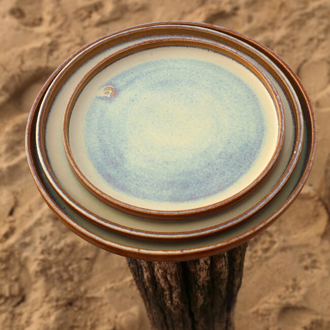 L’assiette fait avec les mains en argile beige et son magnifique glaçage à claire mosterd.