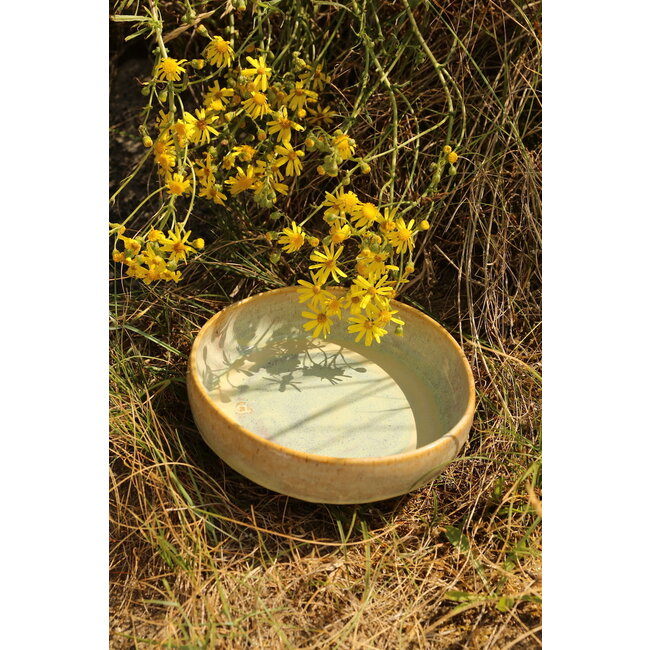 artisann With the turntable handmade scale of Pyerite clay with a beautiful yellow, musterd high-firing glaze.