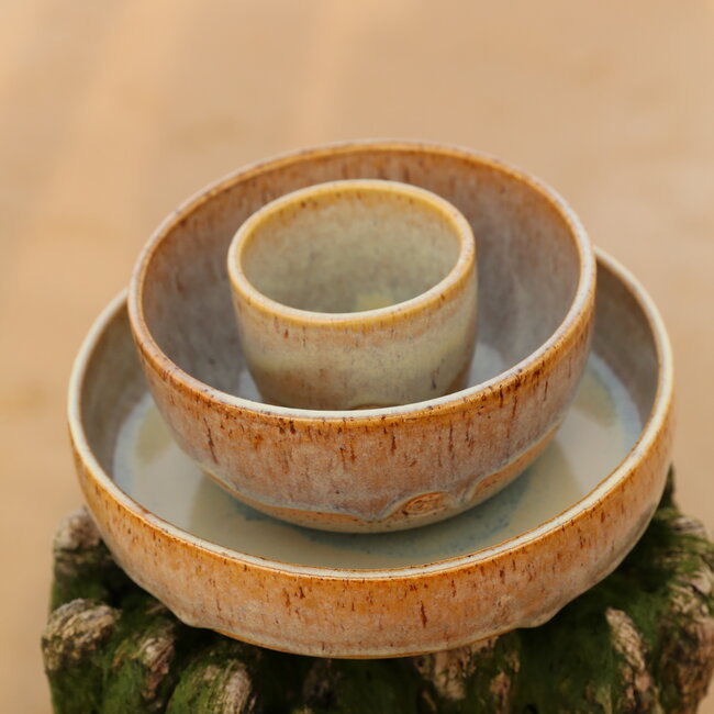 With the turntable handmade bowl of Pyerite clay with a beautiful Floating yellow, musterd high-firing glaze.