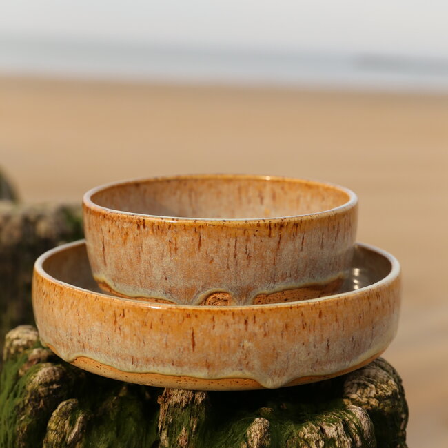 With the turntable handmade bowl of Pyerite clay with a beautiful Floating yellow, musterd high-firing glaze.