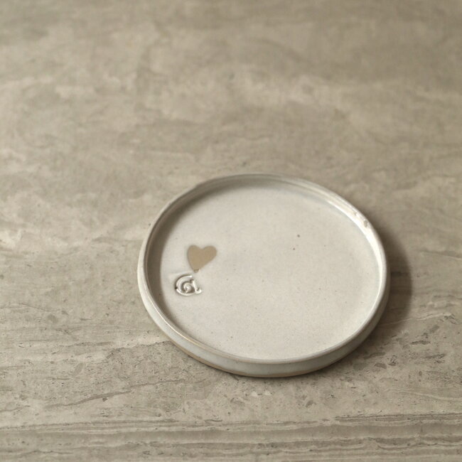 Wit handgemaakte keramisch bord van het servies en de collectie “White Love" met een hartje