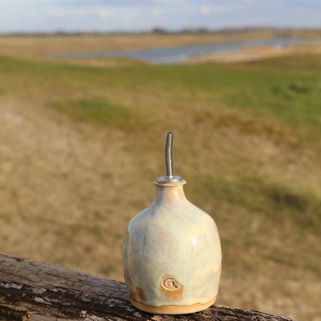 Cette bouteille d'huile est tournée à la main avec le tour de potier pour lui donner une forme ludique unique.