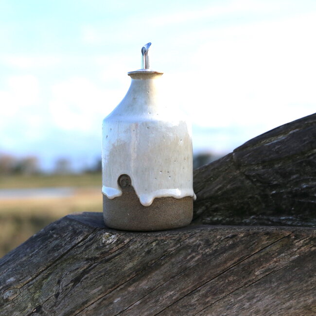 Cette bouteille d'huile est tournée à la main avec le tour de potier pour lui donner une forme ludique unique.