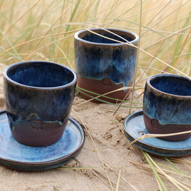 With the turntable handmade cup of Belgien red clay with a beautiful floating blue high firing glaze.