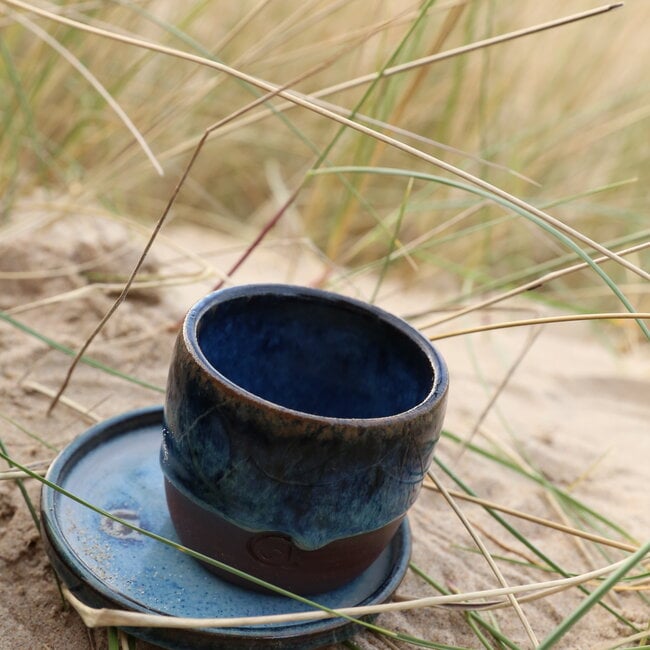 With the turntable handmade cup of Belgien red clay with a beautiful floating blue high firing glaze.