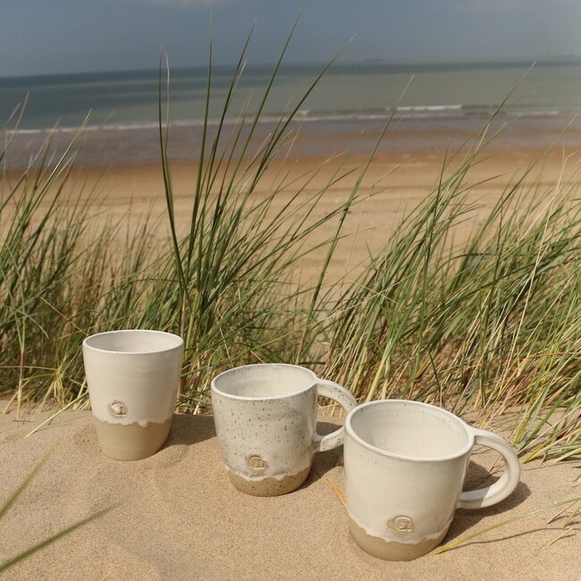 Hedendaagse, handgemaakte keramische mok of tas met oor van het servies en de collectie “White Dunes"