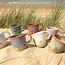 Hedendaagse, handgemaakte keramische mok of tas met oor van het servies en de collectie “White Dunes"