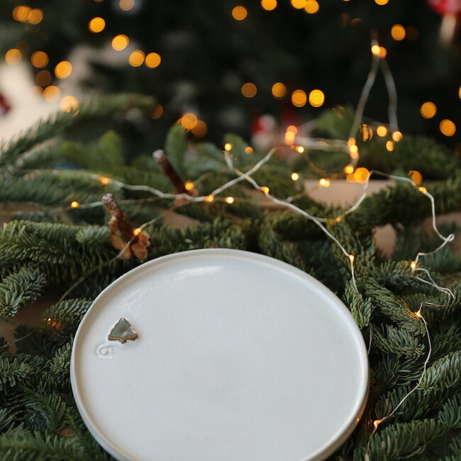 Wit handgemaakte keramisch bord van het servies en de collectie “White Christmas tree" met een muntkleurige kerstboom