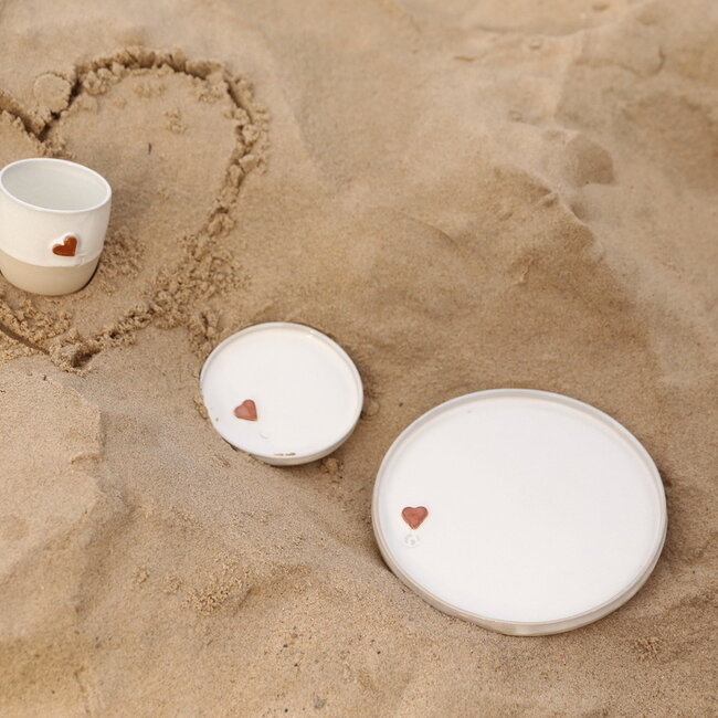White handmade ceramic cup from the “White Heart” service with a sungreen-colored heart