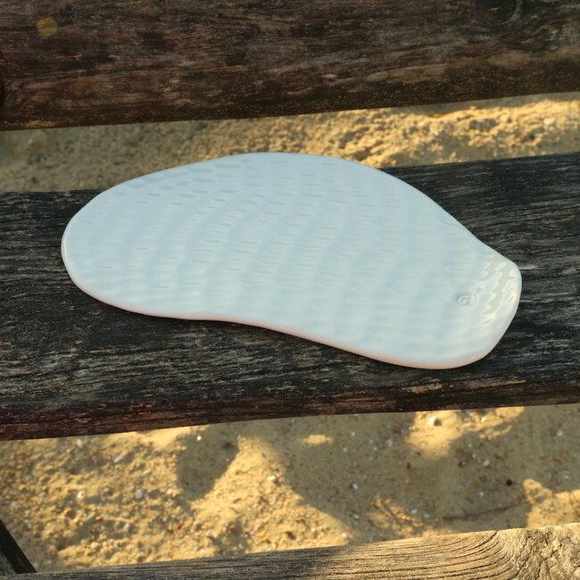 Une assiette unique en porcelaine faite à la main avec une structure ondulée pour présenter des amuses, tapas, pâtisseries à tapas