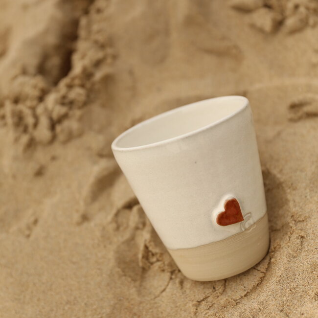 White handmade ceramic tea cup from the “White Heart” service with a sungreen-colored star