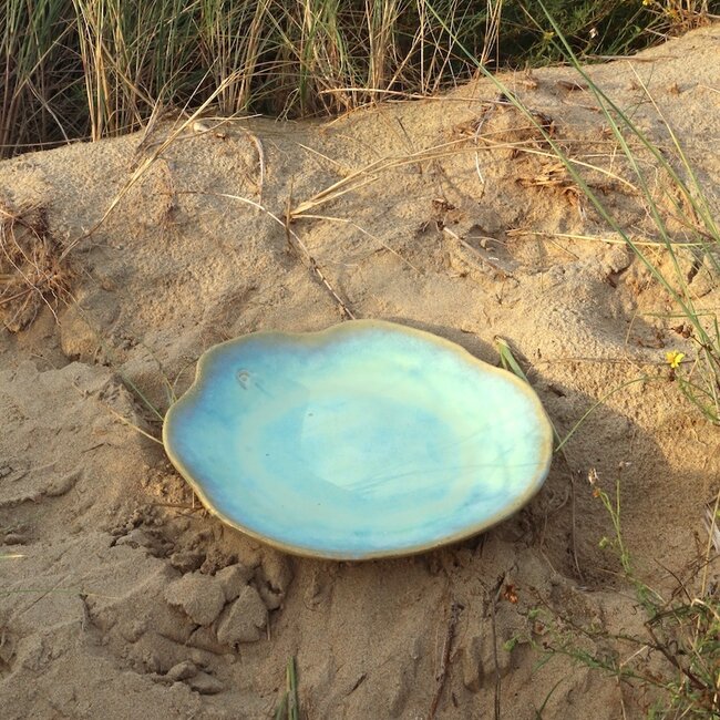 Assiette en céramique Amandine faite à la main en forme de coquillage en émaille lagune de "Chefs Artisann i-lign" pour un usage contemporain ainsi que pour la restauration.