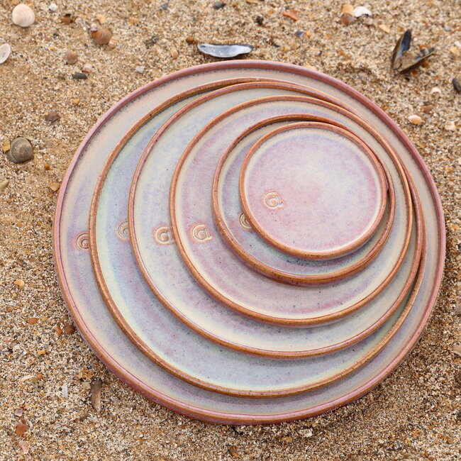 With the turntable handmade plate with speckled Pyerite clay and a beautiful magenta,rose high firing glaze.