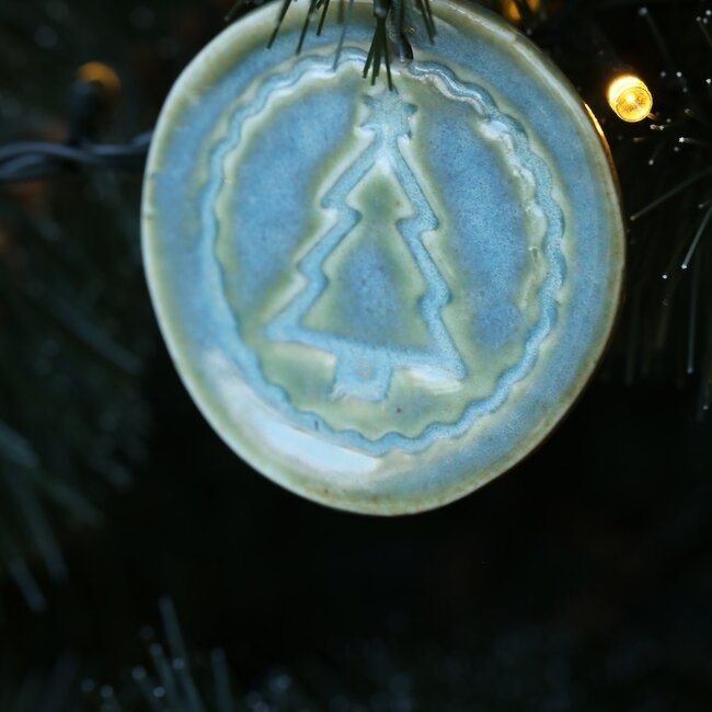 Handmade porcelain Christmas ball decorated with a star, doll, or Christmas tree