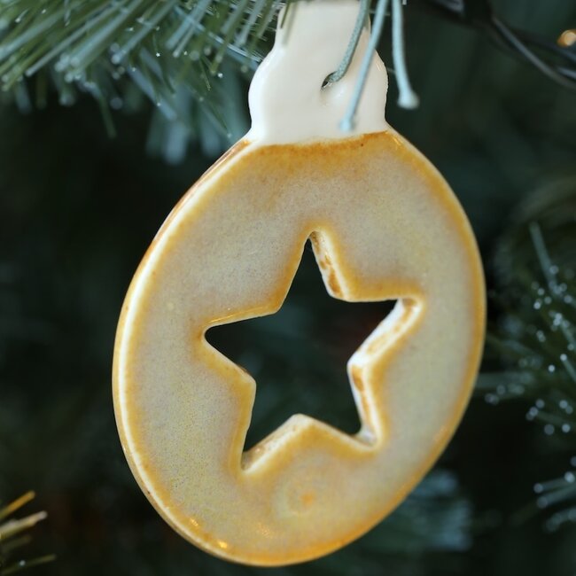 Handmade porcelain Christmas ball decorated with a star, doll, or Christmas tree