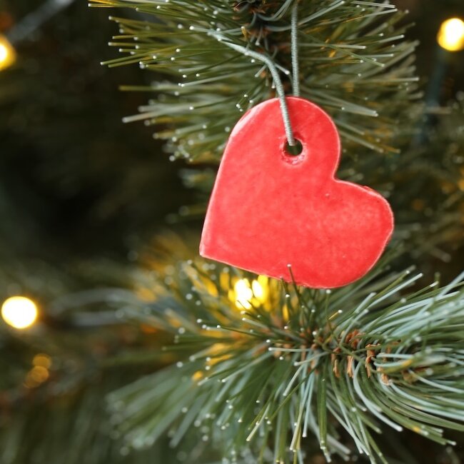 Handgemaakte wit of rood hart in porselein, gebaar van liefde