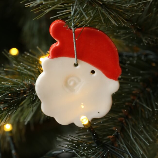 Handgemaakte kerstman in porselein afgewerkt met een rode glazuur