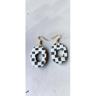Handcrafted clay drop earrings with a black and white checkerboard pattern.