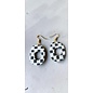 Handcrafted clay drop earrings with a black and white checkerboard pattern.