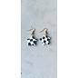 Handcrafted clay drop earrings with a black and white checkerboard pattern.