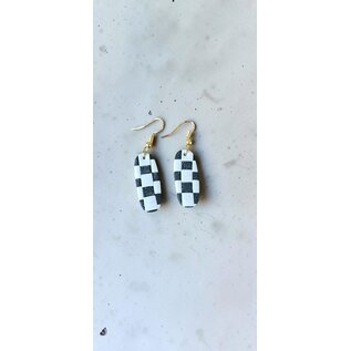Handcrafted clay drop earrings with a black and white checkerboard pattern.