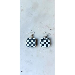 Handcrafted clay drop earrings with a black and white checkerboard pattern.