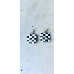Handcrafted clay drop earrings with a black and white checkerboard pattern.