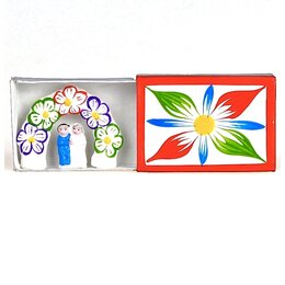 Bruidspaar in luciferdoosje, bloemenboog