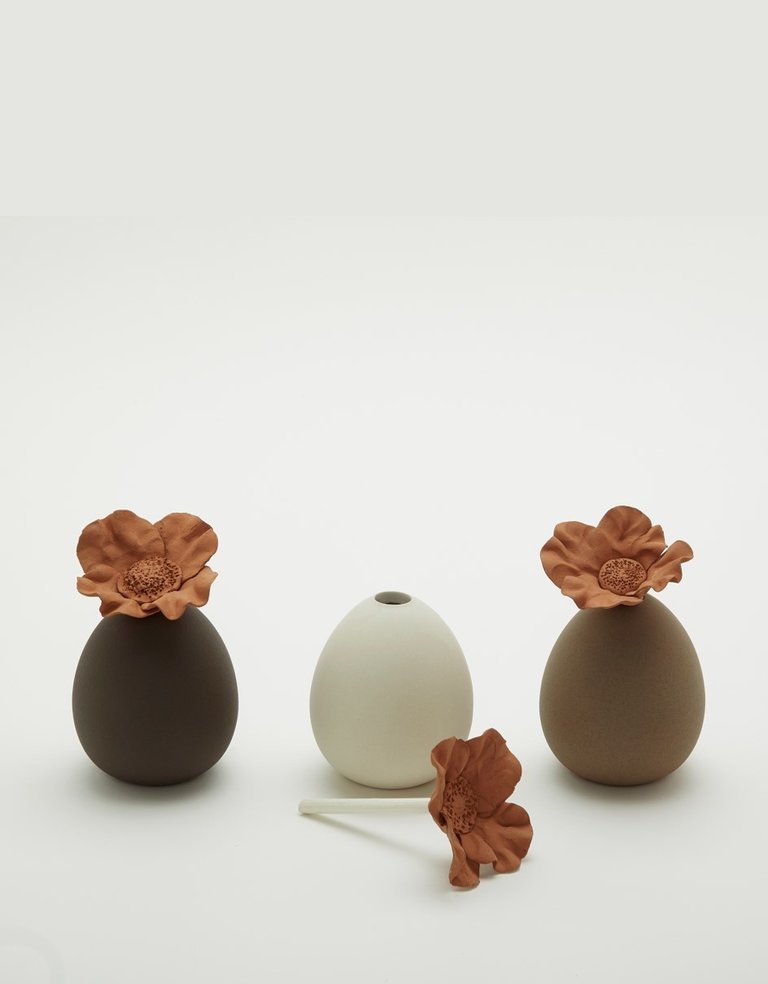 Cream colored ceramic perfume diffuser reservoir with flower